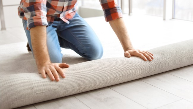 Man rolling carpet for installation | Bob & Pete's Floors